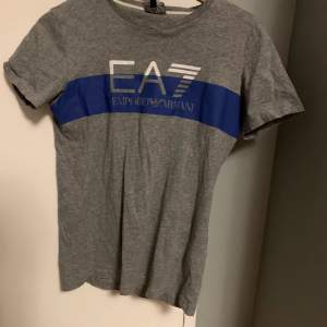 Säljer äkta EA7 t-shirt. Tröjan är köpt från JD sports. Storleken på tröjan är 166 cm, skulle säga att den sitter som en XS. 