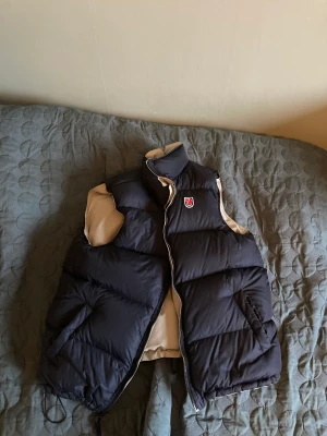 Reverse Fjällräven dunväst. - Reverse fjällräven väst i storlek L/XL (stor storlek) . Väldigt bra kvalitet, använd ett fåtal gånger. 