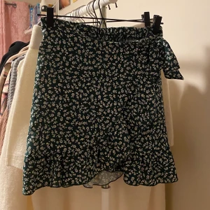 Grön kjol - Supermjuk och skön kjol med en volang som går upp i en rosett i midjan. Den har även lite stretch i midjan som gör den väldigt skön. Använd några gånger men fortfarande i fint skick!!