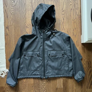 Croppad Regnjacka - Den är i storlek S men med lös passform, ganska bred och kort modell. Jag har normalt S/M. Superfint skick och stilren sportig design! 💥💪🏻 Kan även dras åt i midjan för att få den mer lik en bomberjacka. 