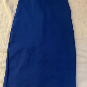 Blå kjol - Oanvänd. Liten öppning på baksidan 