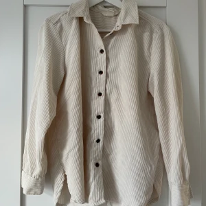 Beige Manchester skjorta  - Säljer en beige Manchester skjorta från H&M i storlek i storlek 36, som är använd en gång. Pris: 250.