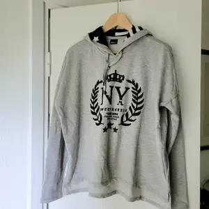 Grå hoodie/huvtröja GinaTricot stl.M. Svart tryck i sammet. Fodrad luva i svart/vitt mönster.  Använd ett par gånger så i stort sett ny!