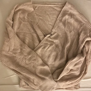 Ljusrosa stickad tröja  - En så så fin ljusrosa stickad tröja i lite tunnare material!! Den går omlott med rätt mycket urringning därav säkerhetsnålen i mitten! Vet inte vart den är ifrån då jag fått tröjan! Men i storlek M   