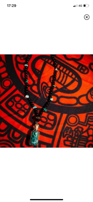 Halsband med glasflaska - Superfint handgjort halsband med pärlor och amazonite. Glasflaskan går att öppna och stenarna som ligger inuti har hål igenom, så flaskans innehåll kan bytas ut och stenarna kan pärlas med. Halsbandet är elastiskt och dras lätt över huvudet🫶🏼Köpt på plick