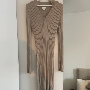Klänning  - Lång klänning med slits på armarna, inte använd