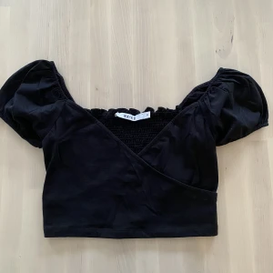 Svart topp - Svart croppad topp.   Använd 1 gång så väldigt bra skick. 