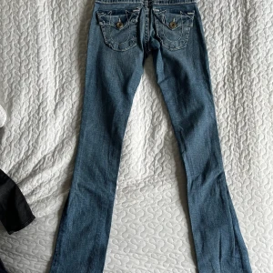 Lågmidjade True Religion  - Super snygga True Religion jeans. Dessa jeans är lågmidjade och vida vid fötterna. De passar tyvärr inte mig längre så det är därför jag säljer:( Skriv till mig för fler bilder eller om du har frågor! (Säljer två par till!!💗💗)