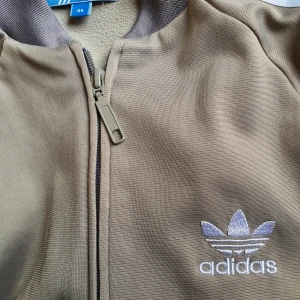 Adidas träningsjacka  - Adidas träningsjacka i storlek 34. Fin khakigrön färg och mycket bra skick! 