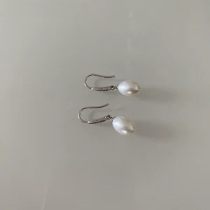 Örhängen i 925 silver med äkta pärla - Säljer ett par så fina örhängen i 925 silver med en äkta pärla! Snappat använda ❤️ Frakten är 13kr för ett frimärke 