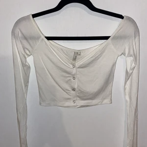 Topp xs - En vit topp i storlek xs fårn NLY. Sitter inte så bra på mig därför jag säljer. Knappar längst fram. Ganska urringad. Kan fixa bilder på hur den sitter på. Orginalpris 199.