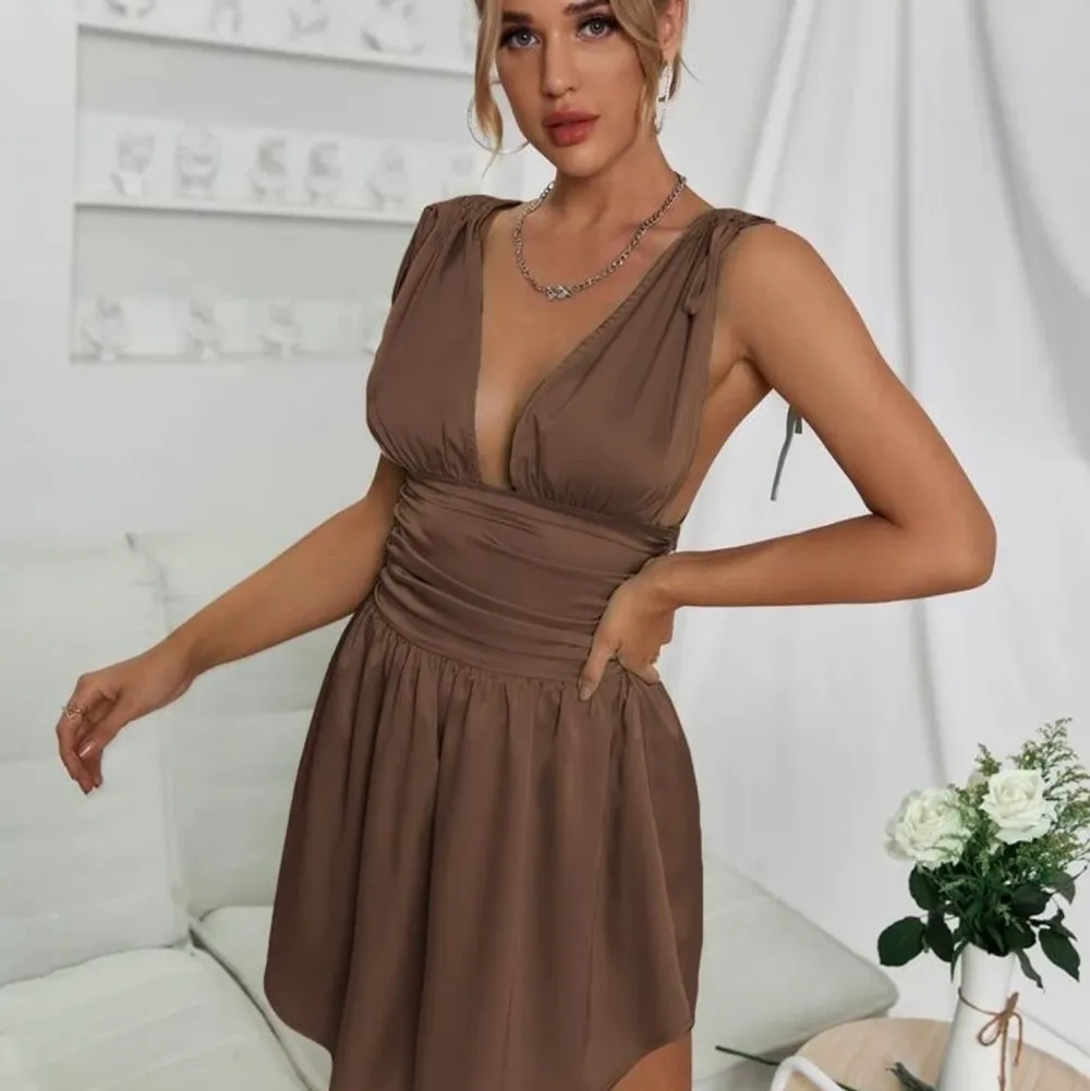 Säljer denna helt nya fina klänning i satin/silke. Fin brun färg. Funkar även som kjol med tröja över eller som topp om man stoppar in kjolen i byxor! Dragkedja i sidan och bandens tjocklek är reglerbara !. Klänningar.