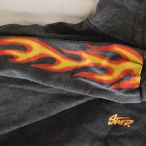 Hoodie - Hoodie i grå/svart tvätt med feta flammor på armarna🔥 Ganska tunn i materialet och skönt oversized. Kan skicka fler bilder om man skulle vilja. (Obs! Lånad bild på slutet) Kram