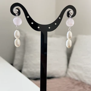 Örhängen med äkta pärlor  - Handgjorda örhängen med sötvattenspärlor och rosenkvarts . Samfraktar. Kontakta för flera bilder eventuellt video. Storlek ca 4 cm Står ej för postens slarv Kontakta för nickelfri alternativ