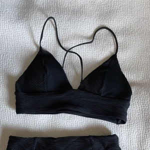 Bikiniset - Svart bikiniset från H&M. Överdelen har korsade snören och underdelen är högmidjad. 