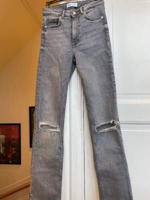 Zara ljusgrå jeans, High waist, långa ben med slits längst ned i sidan, hål över knän. Storlek 34. Grymt snygga till våren!