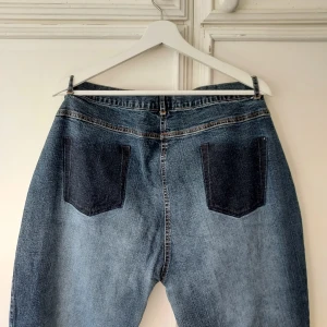 Low-waisted jeans - Low-waisted jeans med ursnygg detalj på rumpan, med endast siluetten av fickor. Det står att det är st52, men skulle säga att de mer är st44/46