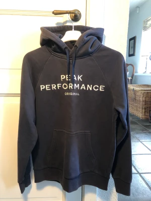 Peak Performance Hoodie  - Mycket fin Hoodie för svalare sommarkvällar! Funkar till alla tillfällen.  Färg: marinblå, vit text Storlek: S Skick: 6/10 Nypris: 800 kr  Mitt pris: 150 kr 
