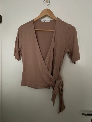 Omlott tröja - Beige omlott tröja från NA-KD. Använt ett fåtal gånger men tycker den sitter förstort på mig. Tror den skulle sitta bättre på någon med större L elr XL 