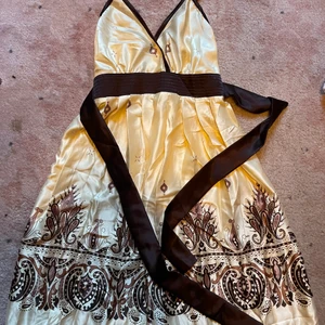 Otroligt fin sommarklänning! - Så fin sommarklänning i siden material! En vacker ljusgul färg med bruna mönster. Stl. Xs-S Finns i rosa också!