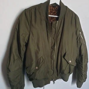 Militärgrön bombarjacka  - Andvänd men i fint skick. Passar perfekt på hösten/våren eftersom insidan är gjort av fejkpäls. Man ser inte insidan när man bär jackan.