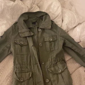 Militär jacka - Säljer denna gröna jeans jacka som jag köpte på loppis men tyckte inte jag passade i den, fint skick perfekt nu i höst. Om flera är intresserade får man buda. Vet inte vad frakten kostar fråga så kan jag kolla💗