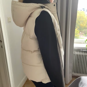 Dunväst från Zara - Säljer nu denna dunvästen som är ifrån Zara. Storlek L men passar mig som brukar ha S-M och så blir den snyggt lite oversized. Endast använd några gånger bara, så ren och fint skick! Perfekt att ha nu i höst.
