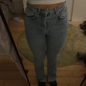 Ett par ljusblå jeans med slit vid slutet av byxorna 