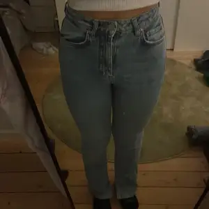 Ett par ljusblå jeans med slit vid slutet av byxorna 