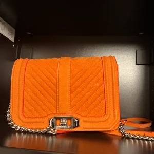 Rebecca Minkoff crossbody väska sammet  - Orange sammet Rebecca Minkoff crossbody väska. Rymlig väska där du får plats med allt du behöver.  Väskan är som ny då jag endast använt den 1 gång.  Nypris 2500kr Kontakta mig för fler bilder eller video  20 cm bred