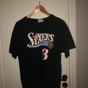 En vintage NBA T-Shirt med namnet Allen Iverson på ryggen från laget Philadelphia 76ers. Lite blekt men ändå riktigt bra skick. Storlek M/L 