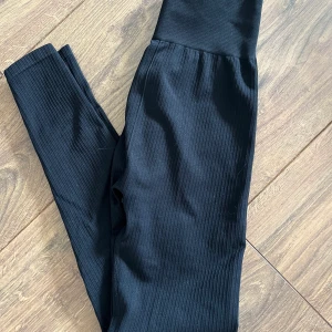 Ribbade träningstights, strl XS - Svarta ribbade träningstights med hög midja. Använda fåtal gånger. Storlek XS. Frakt ingår ej i priset.