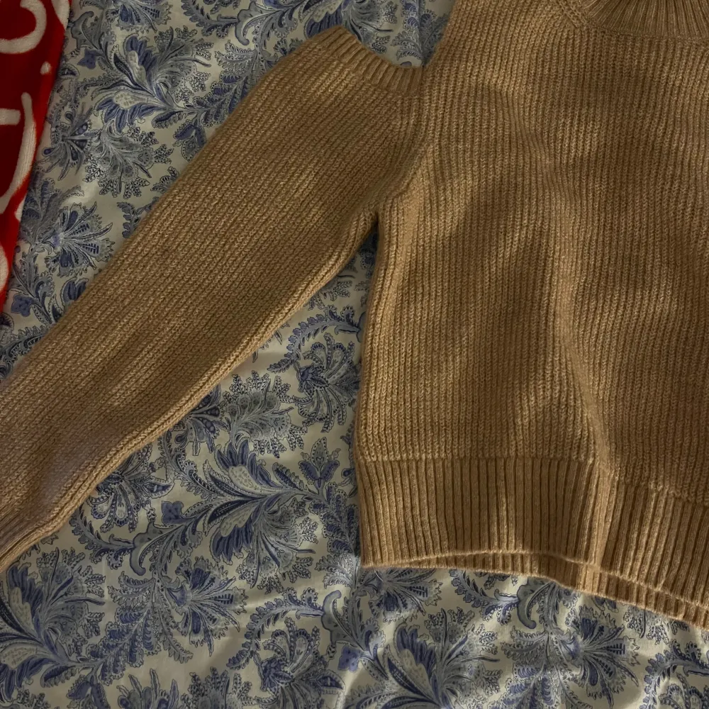 Stickad tröja med öppen axel, storlek M från Gina Tricot, blandning mellan beige och rosa färg. Aldrig bärt den.. Stickat.