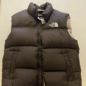 Nortface väst  - Intressekoll på denna vintage North face västen, i en mörkbrun färg med vitt/beige foder, nästintill oanvänd och inga defekter finns