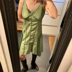 En unik grön klänning i silke, perfekt till ett par boots och en blazer! Står inte strl men passar S-M skulle jag säga. Skick 8/10.