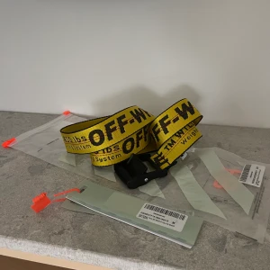 Off White Bälte - Klassiskt industribälte Gult ”Industrial” bälte med  svart spänne. "Off-White BELT" snidat på spännet. Bältet är i ny skick och endast använts ett par gånger. Alla tags finns kvar samt påse osv.