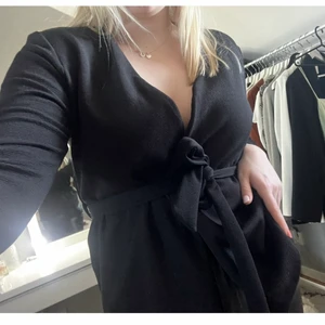 Svart knuttopp/kavaj - En svart tröja med knyte i midjan. Du kan välja att ha den öppen och använda den som en kofta eller ha den knyten!!