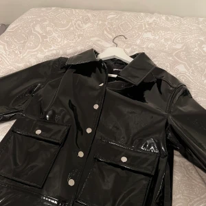 Kort regnjacka - Glansig regnjacka köpt på Gina tricot i höstas. Köptes för 599kr, knappt använd. Säljer för 350kr inkl frakt! 💗