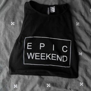 Enkel svart ärmlös topp - Enkel, kort svart ärmlös topp med tryck framtill.  Använd men i bra skick.  Materialet är stretchigt och mjukt, perfekt för sommaren.