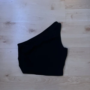 Svart Linne - Svart one shoulder linne, använt men i bra skick, får inte användning av det längre 