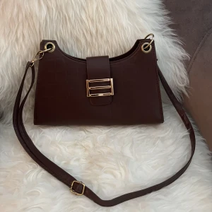 Väska - Brun croc väska med gulddetalj. Kan bäras på axeln eller crossbody. Nyskick