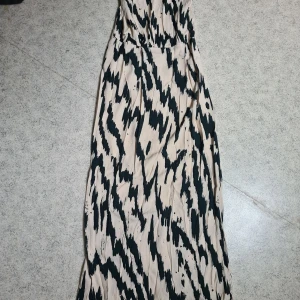 Superfin långklänning - Långklänning från samsö-samsö. Zebramönstrad. Öppen rygg, med fina spetsderaljer,   med dragkedja.  Liten sprund baktill. Stel 38/40