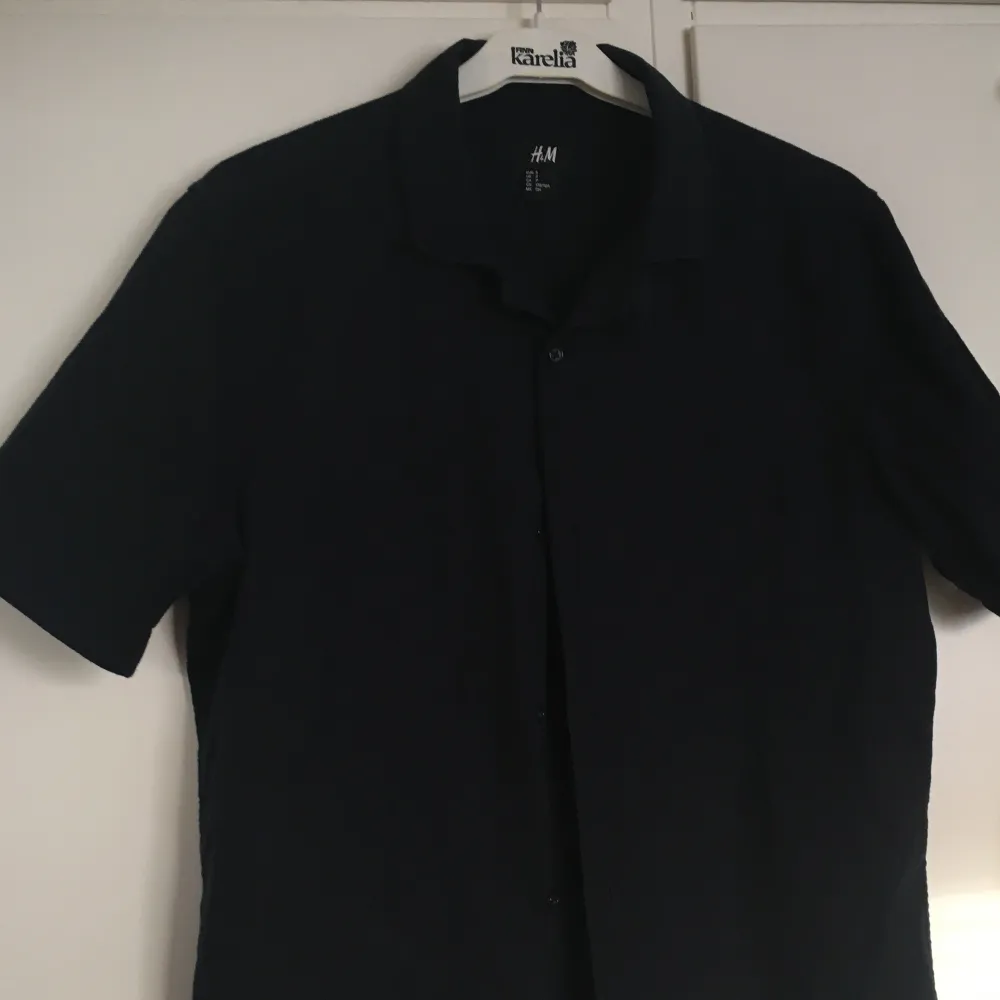 Marinblå (nästan svart) skjorta i bomull från H&M. Sparsamt använd & i gott skick. Herrstorlek S så relativt långsmal modell. Priset inkluderar frakt, meddela vid frågor!. Skjortor.