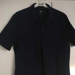 Marinblå (nästan svart) skjorta i bomull från H&M. Sparsamt använd & i gott skick. Herrstorlek S så relativt långsmal modell. Priset inkluderar frakt, meddela vid frågor!
