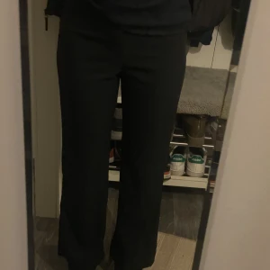 Svarta Högmidjade Kostymbyxor  - Tunna och högmidjade kostymbyxor, ”fladdriga” i materialet. Använt 2 gånger och säljer pga att dessa är för korta på mig (168 cm). 