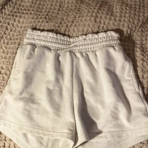 Vita shorts från LINDEX. - Här hittar du ett par vita barn shorts.  Produkten bär st:158/164 och kommer ifrån LINDEX.  Shortsen har jag haft i c 1,5 år  så inga tecken på något felaktigt eller lik   OBS: Längst ner vid shortsen  slut så är den nopprig men annars inga tydliga fel!