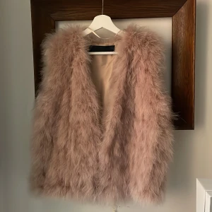 Glammig fjäderväst i rosa, Zara Woman Studio - Ursnygg knäppbar v-ringad väst i värmande dun. Puderrosa. Försiktigt använd. Nyår är snart här… 