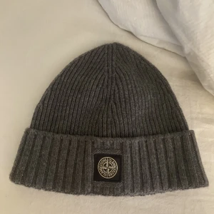 stone island mössa - mörkgrå stone island mössa som inte kommer till användning i nyskick. Mössan är i storlek 3 barn men passar mig lika bra som vilken mössa som. Har äkthetsbevis ifall så behövs.