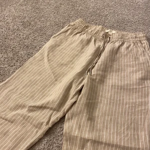 Linnebyxor  - Beiga linnebyxor ifrån HM i stolek 34. Jag har själv köpt dessa linnebyxor på second hand men de har inte kommit till användning hemma hos mej. De ser ut som nya. Säljer för att de är för korta för mig, byxorna passar någon som är 160 cm eller kortare. 