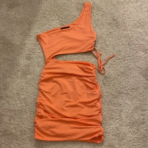 Klänning - Klänning i korallfärg från SHEIN med utskuren detalj. 